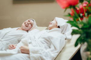 two ladies in robes laughing on group spa day